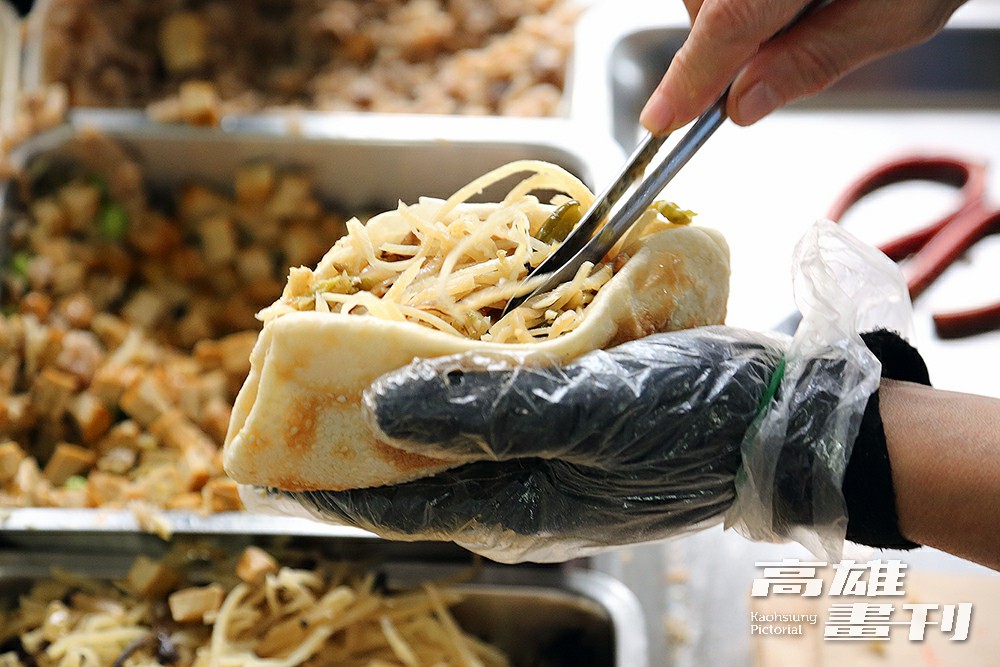剪開的燒餅中塞入多到快滿出來的餡料，提供一天滿滿的活力。(攝影/Carter)